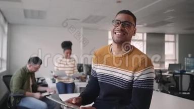 技术娴熟的年轻非洲商人正和<strong>同事一起</strong>在办公室里<strong>看</strong>着手持数码平板电脑的相机